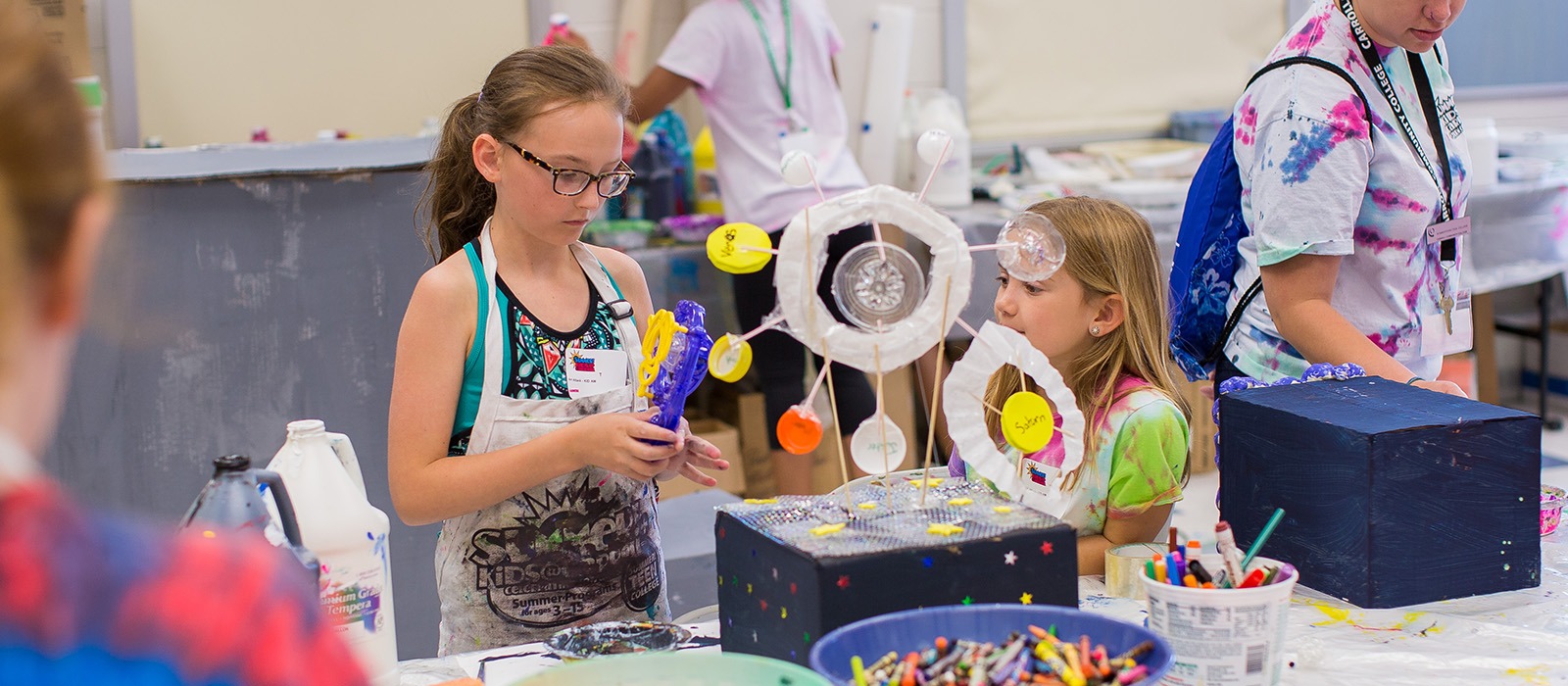 Two girls participating in a craft activity.